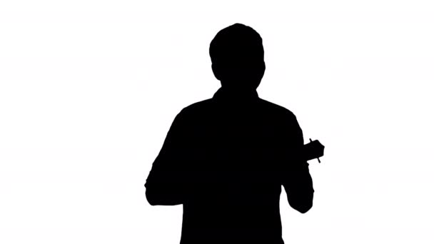 Silueta Mladý muž hraje ukulele při chůzi. — Stock video