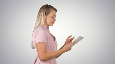 Güzel bir kadın tablet kullanır ve arkaplanda yürür..