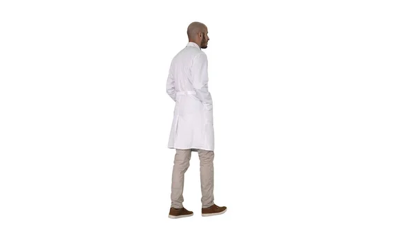 Ходячий врач в халате на белом фоне. — стоковое фото