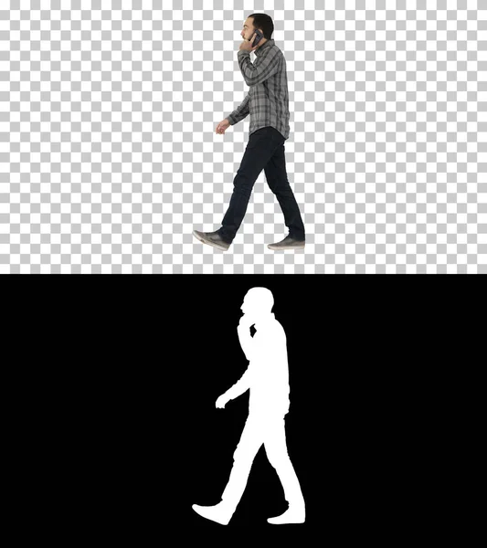 Mladý vousatý muž chodí a mluví na mobilním telefonu, Alpha — Stock fotografie