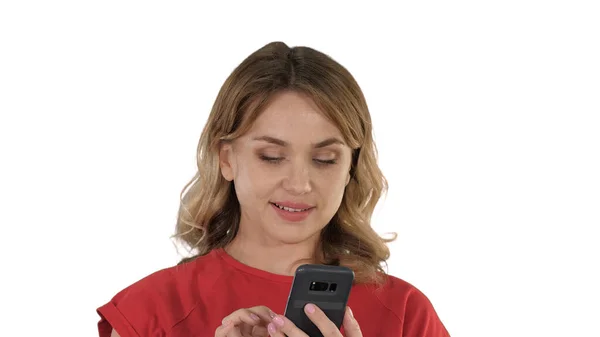 Hübsche Blondine schickt einen Text auf ihrem Handy auf weißem Rücken — Stockfoto