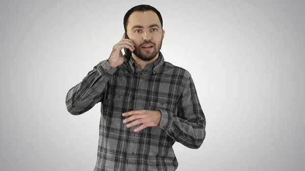 Un homme parle au téléphone et sourit sur fond de dégradé — Photo