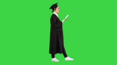 Yeşil Ekran, Chroma Key 'i beklerken, mezuniyet cüppesi giymiş sinirli bir bayan öğrenci diplomasını sallıyor..