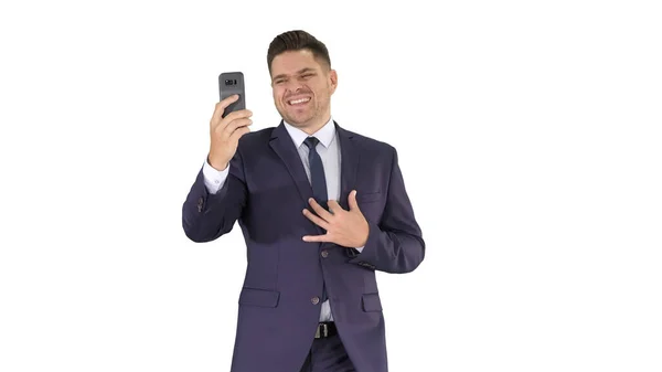 Young businessman using smartphone to videocall to business partner while walking on white background. — Stock Photo, Image