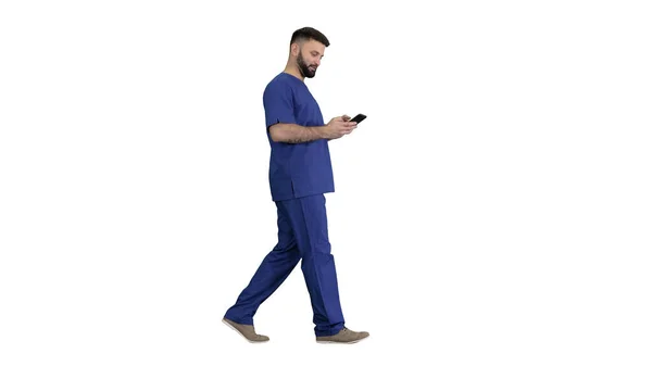 Chirurg Arzt zu Fuß und mit seinem Handy auf weißem Hintergrund. — Stockfoto