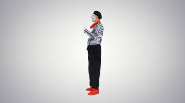 Değişken arkaplanda hayali kapıdan geçen pandomimci.