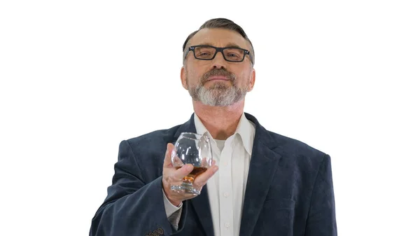 Mature homme en costume buvant du whisky ou du cognac sur fond blanc — Photo