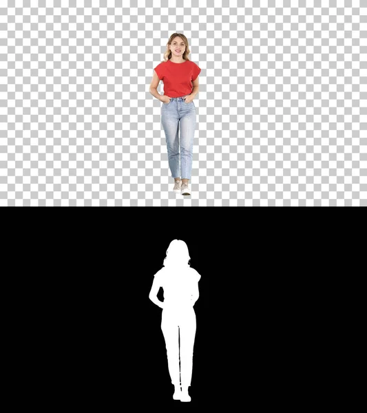 Blond woman walking with hands in her pockets and talking to cam — Stock Photo, Image