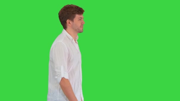 Hombre joven casual caminando y mirando hacia adelante en una pantalla verde, Chroma Key. — Vídeos de Stock