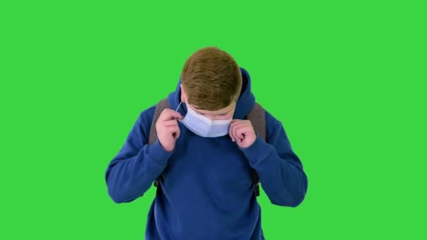 Übergewichtiger junger Mann beim Gehen und Ausziehen medizinischer Maske auf einem Green Screen, Chroma Key. — Stockvideo