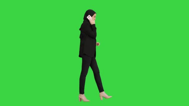 Çekici modern Müslüman kadın yeşil ekranda yürürken ve konuşurken, Chroma Key. — Stok video