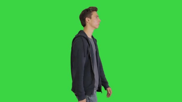 Aantrekkelijke casual jonge man lopen op een groen scherm, Chroma Key. — Stockvideo