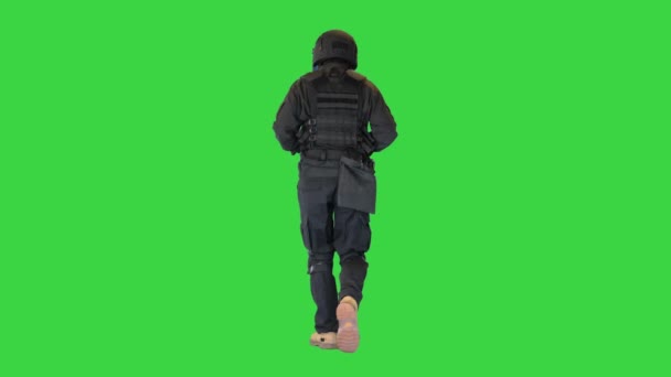 緑の画面、クロマキー上で実行されている制服を着たSWAT男を飲みます. — ストック動画