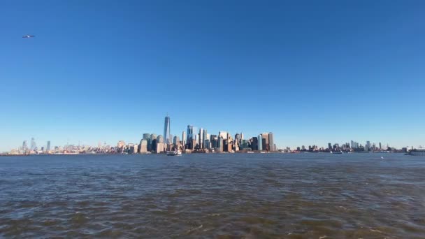 Standbeeld Cruises ferry en Manhattan skyline, uitzicht vanaf Ellis Island — Stockvideo