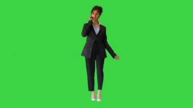 Melez bir kadın, yeşil ekranda yürürken telefonla konuşuyor, Chroma Key..