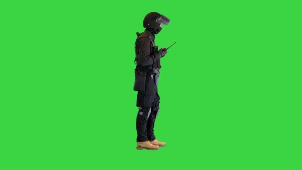 Oproerpolitie agent in volledig uniform in gesprek op een radio op een groen scherm, Chroma Key. — Stockvideo