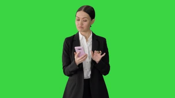 Nespokojeně vypadající podnikatelka používající telefon na zelené obrazovce, Chroma Key. — Stock video