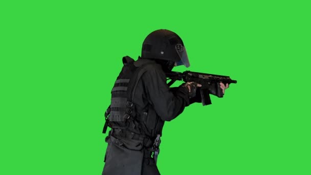 Gewapende SWAT politieagent mikt met een geweer op een groen scherm, Chroma Key. — Stockvideo