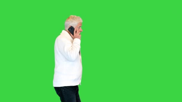 Starý muž chodí a mluví na mobilním telefonu na zelené obrazovce, Chroma Key. — Stock video