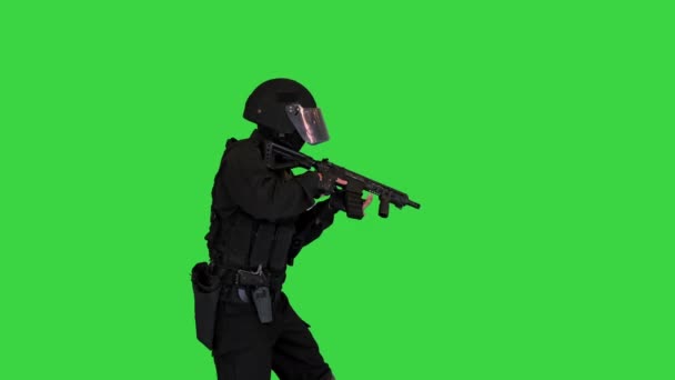 Protiteroristický policista kráčí s kulometem a míří pistolí na zelenou obrazovku, Chroma Key. — Stock video