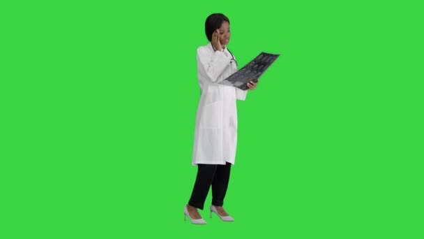 Kadın tıp doktoru hastaların beyin röntgenlerini yeşil ekranda okuyor, Chroma Key. — Stok video