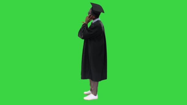緑の画面で幸せなニュースを共有する電話で話して卒業ローブのアフリカ系アメリカ人男性学生を笑顔,クロマキー. — ストック動画
