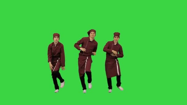 Tři legrační kuchaři v červené uniformě tančí proti zelenému pozadí na zelené obrazovce, Chroma Key. — Stock video