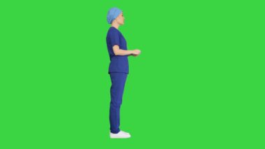 Mavi üniformalı kadın doktor yeşil ekranda tıbbi bakım hakkında konuşuyor, Chroma Key..