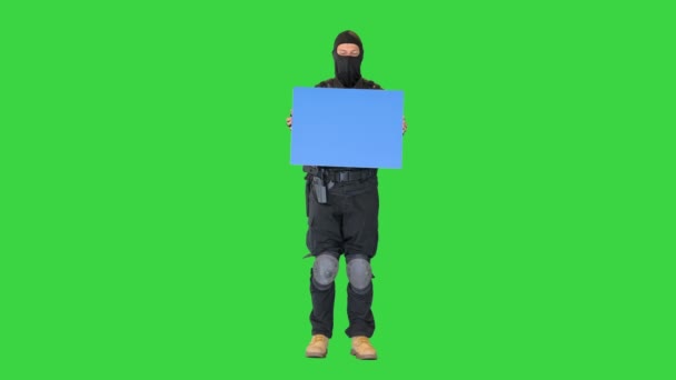 Poliziotto antisommossa in piedi con un plakard vuoto su uno schermo verde, Chroma Key. — Video Stock