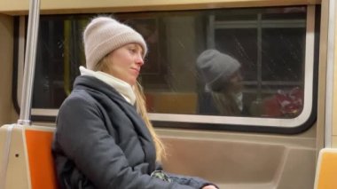 Trende yorgun genç bir kadın metroda, düşüncelerinin derinliklerinde.