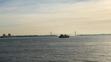 Yukarı New York Körfezi 'nde turistlerle dolu bir feribot. Arka planda Verrazzano-Narrows Köprüsü.
