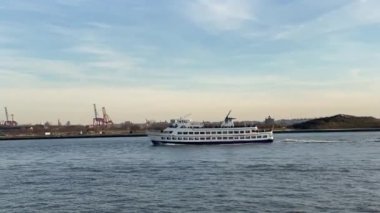 New York Körfezi 'nin yukarısındaki valilik adasında turistlerle dolu bir feribot.