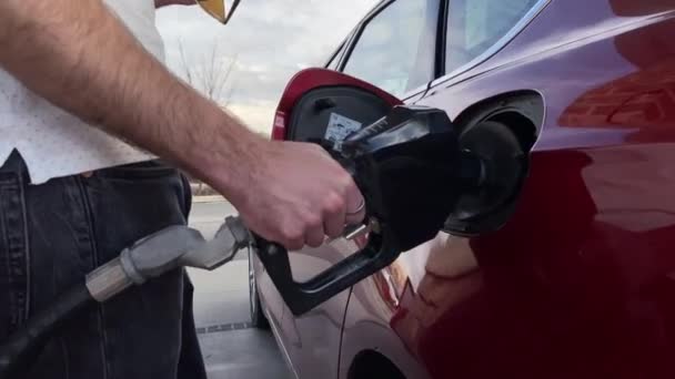 Ein junger Mann beim Tanken seines Autos an der Tankstelle, Nahaufnahme -Video — Stockvideo