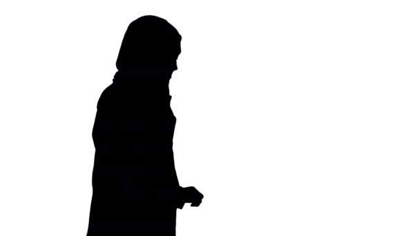 Silhueta mulher muçulmana moderna atraente andando e falando no telefone celular. — Vídeo de Stock