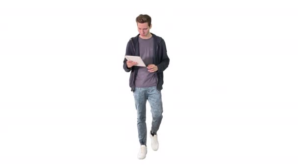 Casual man using tablet while walking on white background. — Stock Video