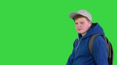 Yakışıklı okul çocuğu yeşil ekranda müzik dinlerken yanından geçiyor, Chroma Key.