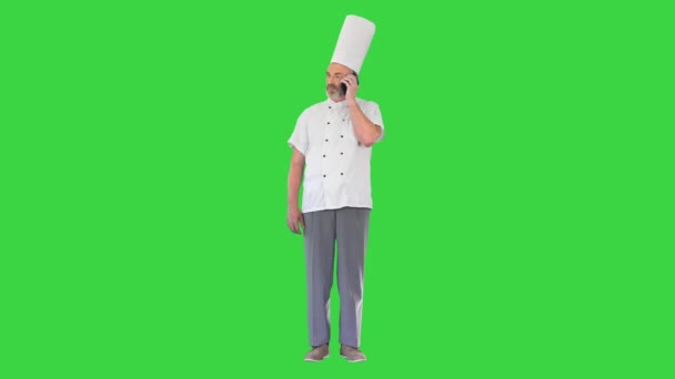 Konzentrierte männliche Köchin telefoniert auf einem Green Screen, Chroma Key. — Stockvideo