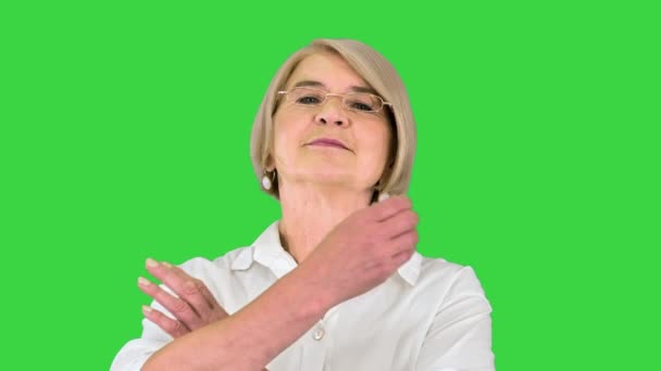 古いですスマート女性で眼鏡に立ってクロス手で緑の画面、クロマキー. — ストック動画