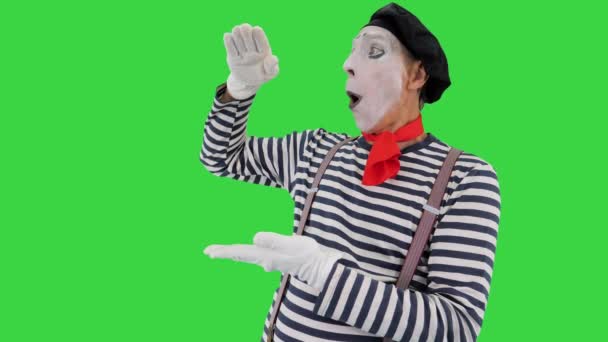 Male mime artist performing showing growth, high interest rates, high income with his hands on a Green Screen, Chroma Key. — Stock Video