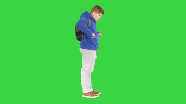 緑の画面に立ってリュックを持つ若い学生,クロマキー. — ストック動画