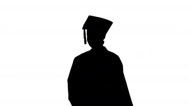 Silhouette Χαμογελώντας γυναίκα απόφοιτος στο mortarboard γραπτών μηνυμάτων στο τηλέφωνό της, ενώ το περπάτημα. — Αρχείο Βίντεο