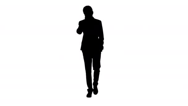 Silhouette Guapo joven hombre de negocios hablando por teléfono mientras camina. — Vídeos de Stock