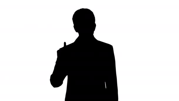 Silhouet Zelfverzekerde jonge zakenman die zijn vinger opsteekt en armen vouwt terwijl hij naar de camera kijkt. — Stockvideo