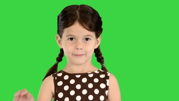 Menina morena bonita em polka dot vestido acenando para a câmera em uma tela verde, Chroma Key. — Vídeo de Stock