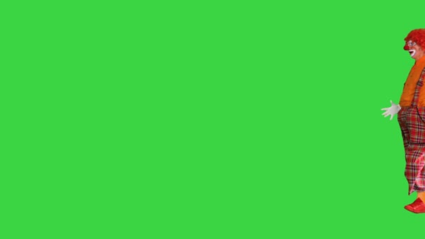 緑の画面、クロマキー上のカメラに面白い外観を作るために歩いてクラウン. — ストック動画