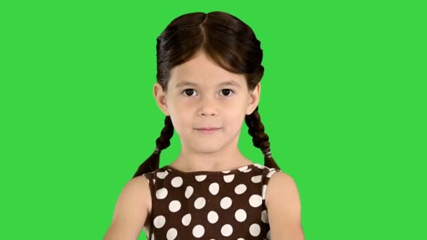 Krásná mladá dívka v polka-dot šaty ukazující její věk s prsty a vyslovuje to do kamery na zelené obrazovce, Chroma Key. — Stock video