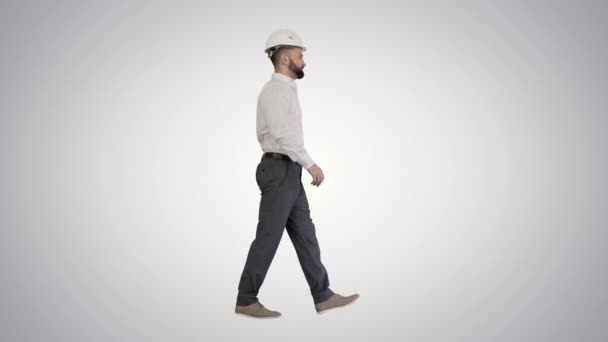 Бізнесмен у формальному одязі та білому хардхаті, що ходить на градієнтному фоні . — стокове відео