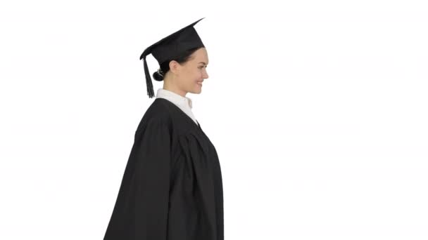 Улыбающаяся студентка в выпускном халате идет с дипломом на белом фоне. — стоковое видео