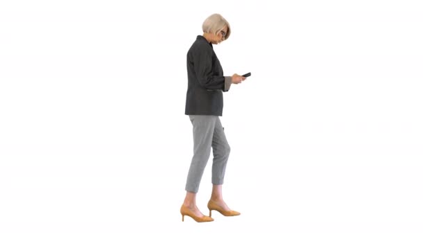 Elegáns idős nő használ okostelefon séta közben fehér háttér. — Stock videók