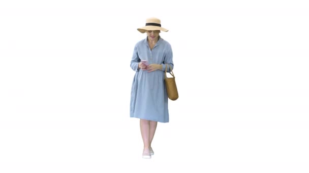 Mujer embarazada joven en sombrero de moda caminando y usando su teléfono sobre fondo blanco. — Vídeo de stock